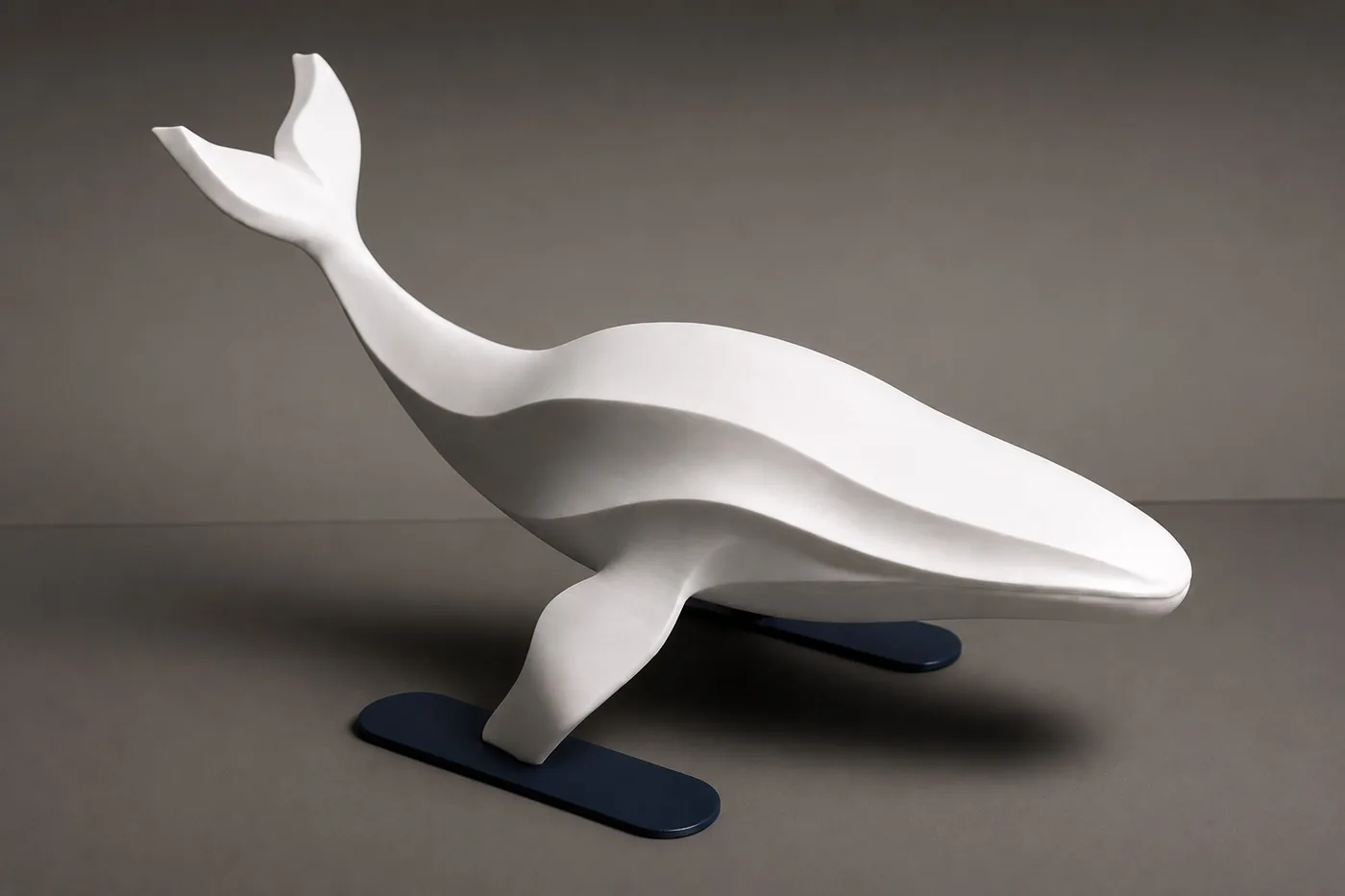 Minimalist white sculpture of a diving whale